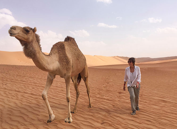 Liz Torlée with camel in desert